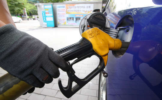 지난 6월 14일 오후 서울 시내의 한 주유소에서 직원이 주유를 하고 있다.    이날 한국석유공사 유가정보 시스템 오피넷에 따르면 서울 지역의 휘발유 평균가격은 1666.87원, 전국 평균유가는 1579.08원을 기록했다. 연합뉴스